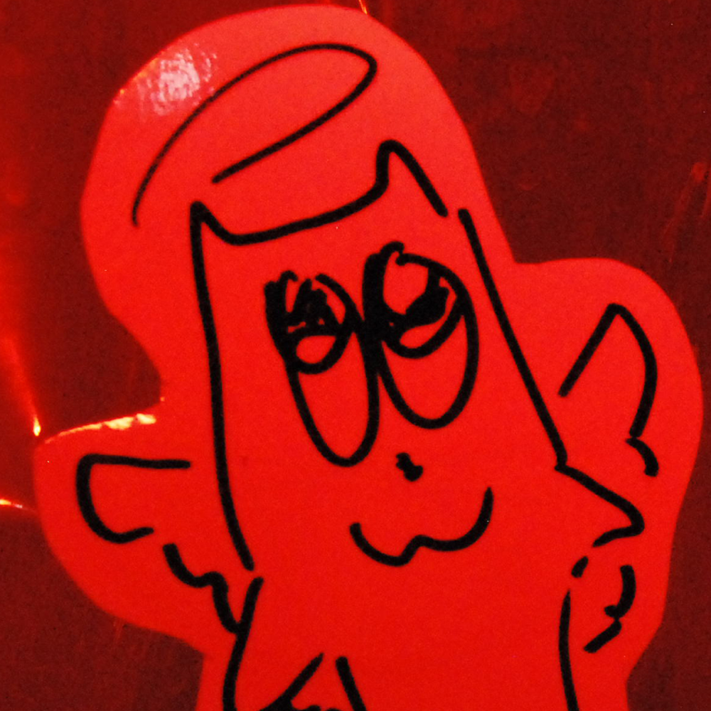 red image of a paper cutout of a drawing of a cartoon cat with halo and angel wings